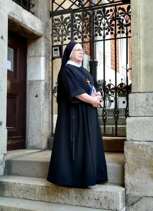 一位修女手捧圣经,神情严肃地看着远方