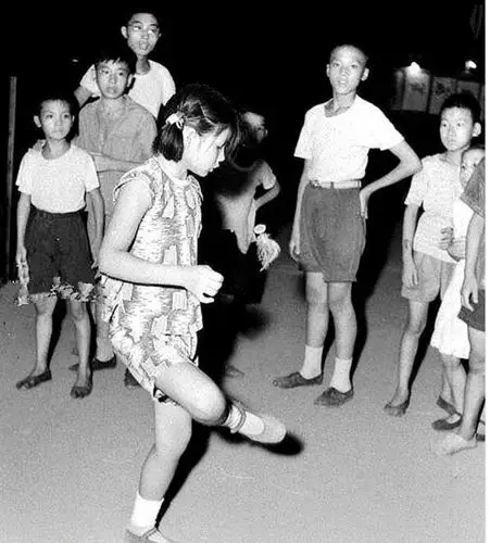 照片中是孩子们一起聚在一起踢毽子的场景,那个年代没有手机,电脑