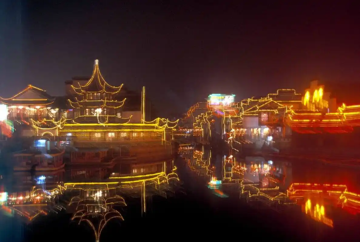 苏州夜晚的船游古运河如诗如画,两岸灯光倒映水中五彩斑斓,古建筑庄重