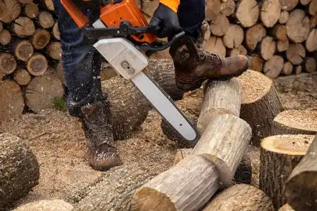 电锯在锯木头.用锯子,灰尘砍木头的人照片