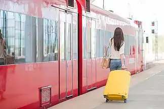 在 i>车 /i>站 i>乘 /i> i>火 /i> i>车 /i>旅行的女人背着包的背影