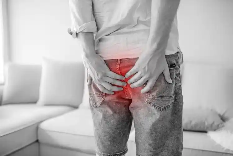男子手抱着他的臀部因为有腹痛和痔疮肚子痛