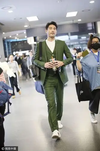 高以翔穿墨绿色西装边走边签名 获迷妹包围不忘挥手打招呼