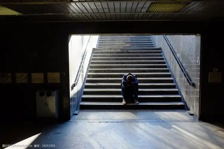 楼梯上趴在膝盖上的男人图片