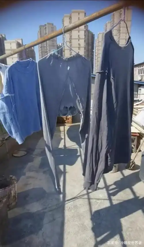 视频中在屋顶晾晒衣服的竹竿上挂着女子刚刚给老公洗完的毛衣,秋衣和