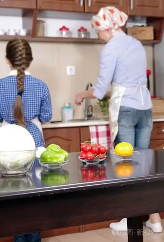 小女孩正帮她妈妈做饭照片-正版商用图片0dpqf6-摄图新视界