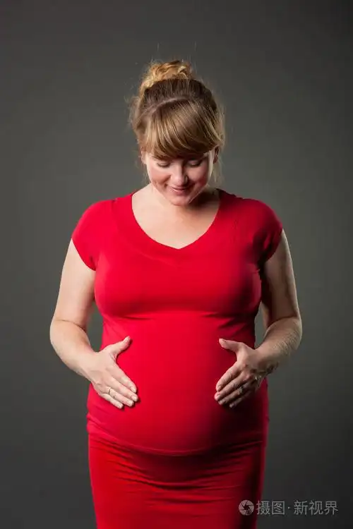 美丽的孕妇穿红衣服的肖像