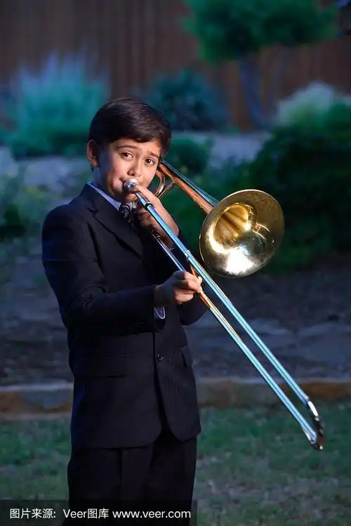 12岁男孩在户外吹长号的肖像