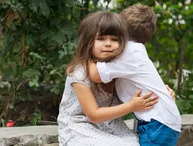 两个小兄妹朋友在夏日阳光明媚的日子里互相拥抱.家庭的爱.