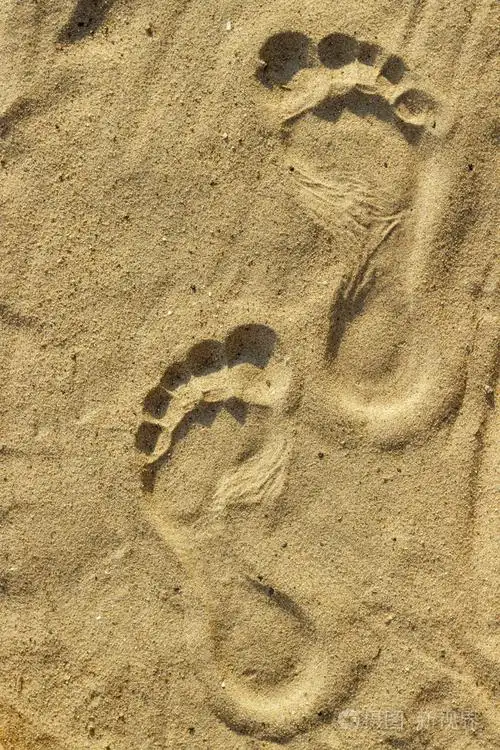 人的脚印在沙滩上的沙子上的印记