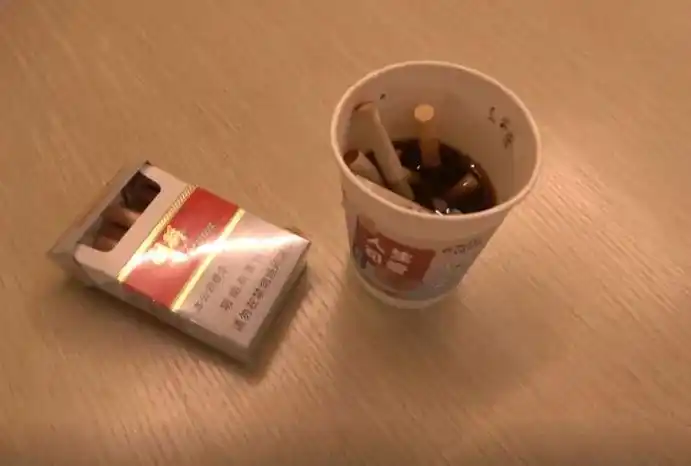 酒吧负责人办公室内用纸杯做的烟灰缸,里面塞满了烟头.(彭成城 摄)