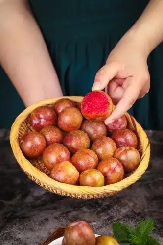 手里拿着一篮李子 三华李