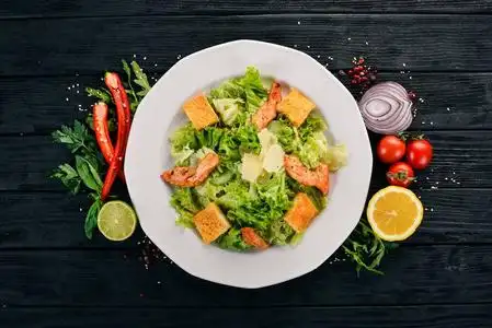 凯撒沙拉配鸡肉和新鲜蔬菜.在一个木质的背景.顶部视图.复制空间照片