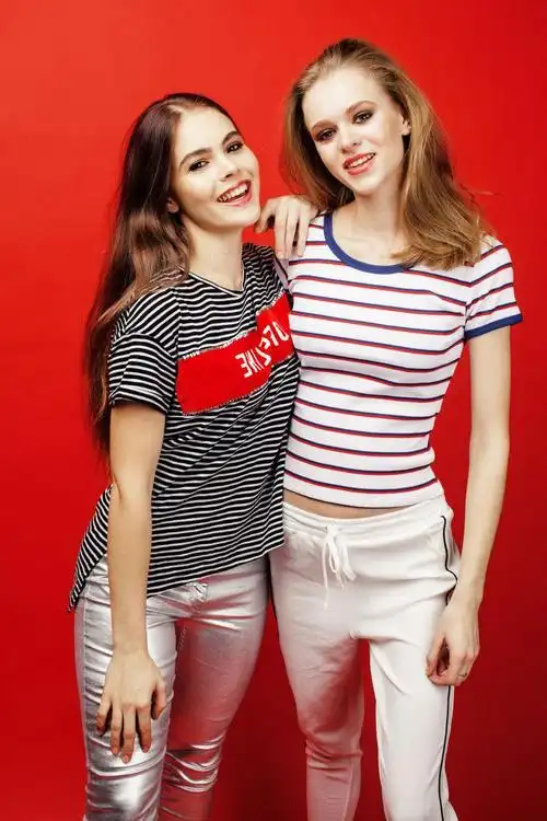 图片 创意图片 红色背景下一个美女头和双手搭在另一个美女肩膀上