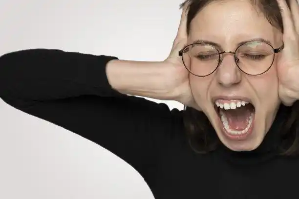 年轻愤怒的女人大声呼喊着孤立的灰色背景照片摄影图片