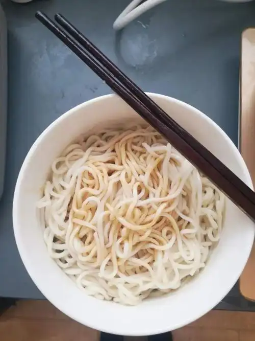 附近的盒饭店还没开门,他只能以最"粗糙"的方式来填饱肚子—白水煮面