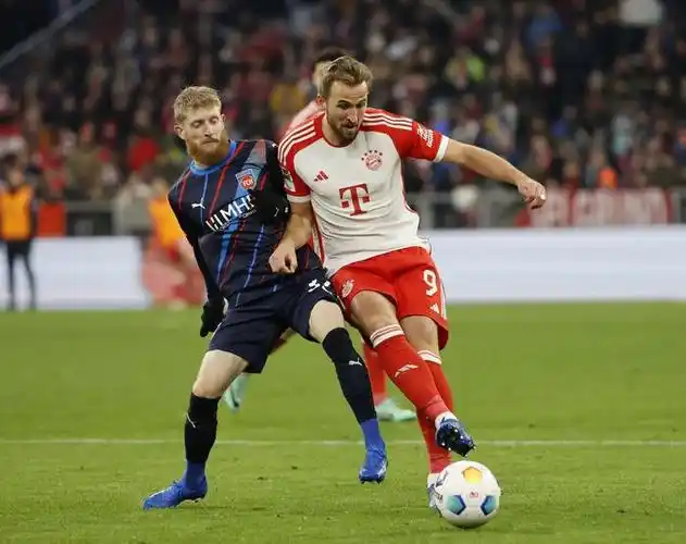 拜仁慕尼黑队球员凯恩(左)在打进球队第二粒进球后与队友乌帕梅卡诺