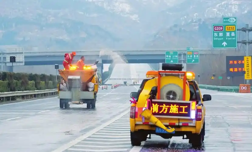 图为公路养护人员在侯平高速运三段及时抛撒融雪剂,全力做好冰雪天气