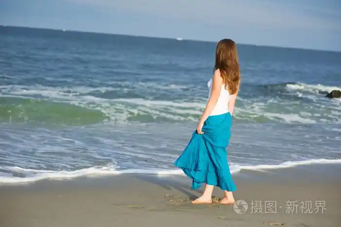 美丽的年轻女子走在海边