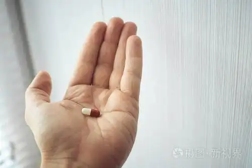 一个男人在手掌上拿着一只多色的药片.普通感冒的治疗方法