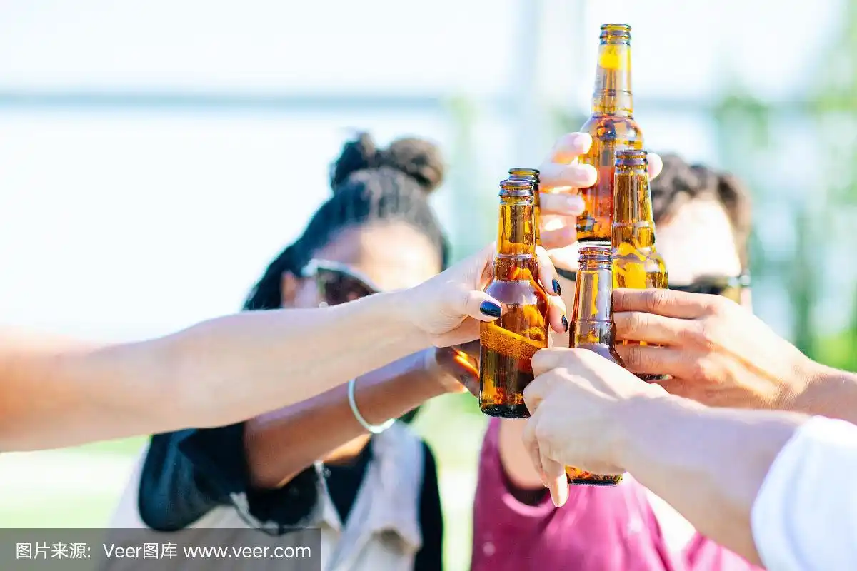 微笑的朋友在节日里碰杯啤酒.