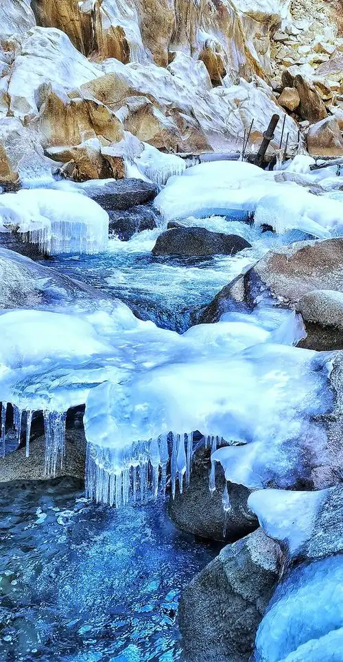 帕米尔高原的冬天河水结冰冰河下面水继续流淌冰河和水的颜色在强烈的
