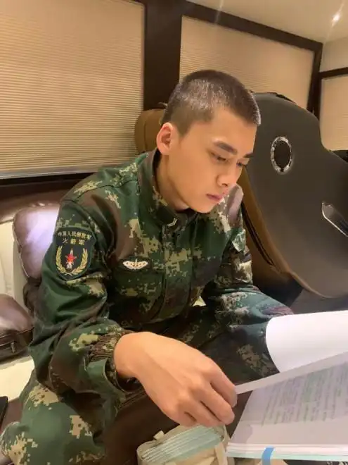 照片中,寸头发型的李易峰身穿中国人民解放军火箭军军装,端坐在沙发上