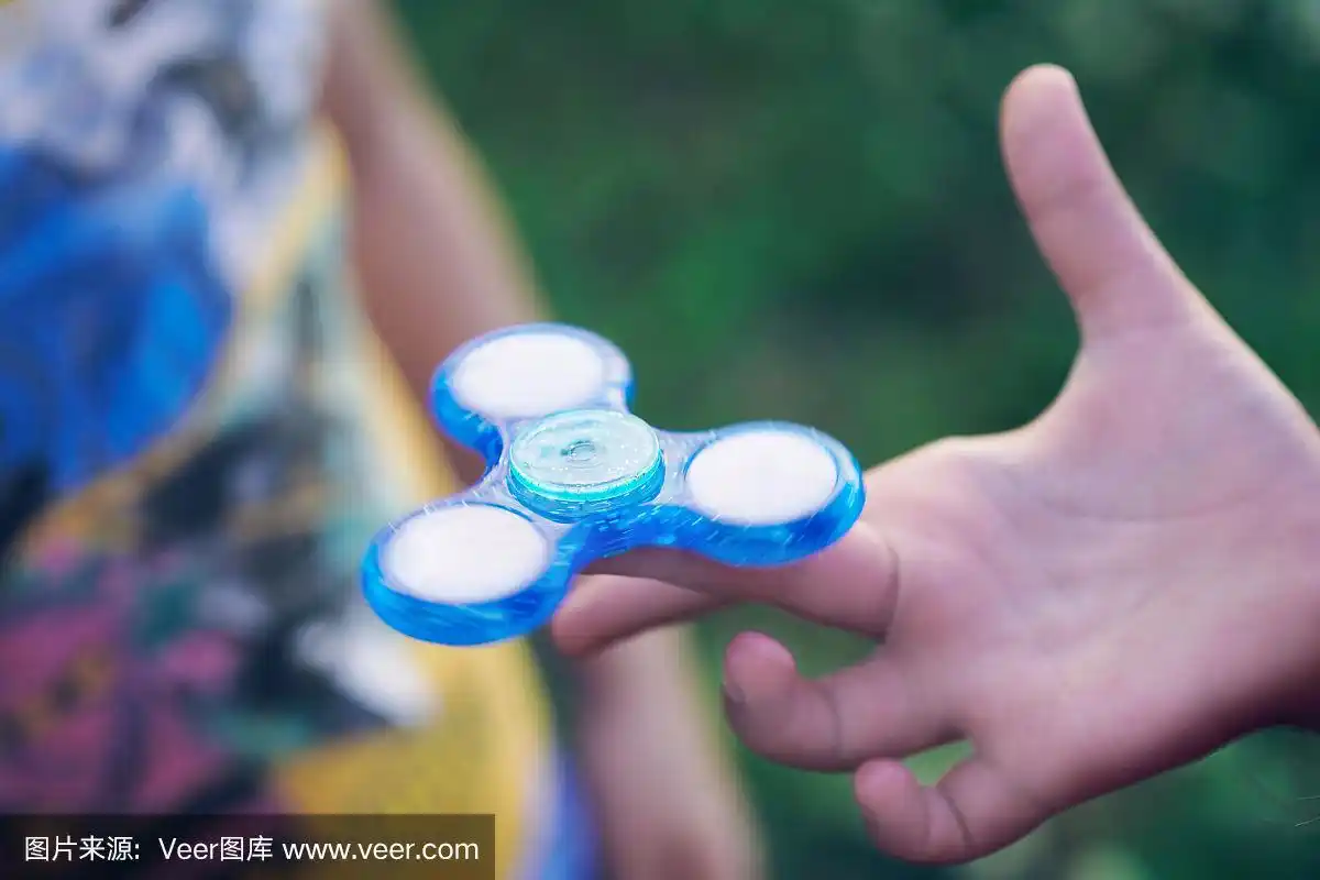 小男孩玩指尖陀螺压力缓解玩具.只用手和玩具
