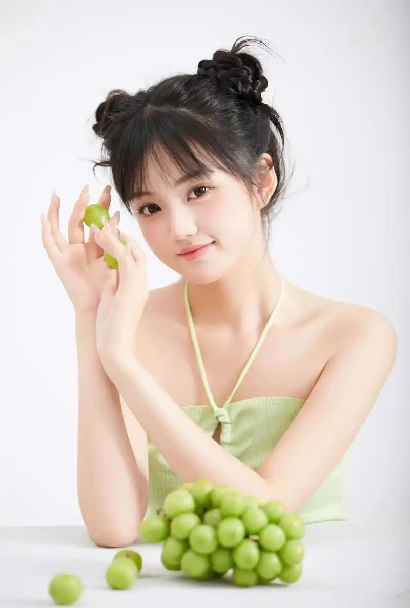 优雅的姿态中,她手持鲜绿葡萄,如艺术品般呈现.