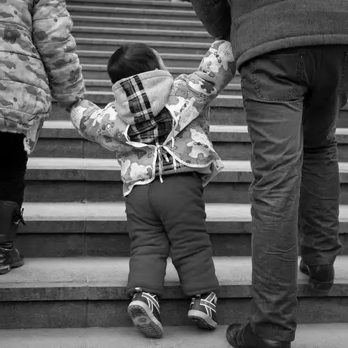 这些年龄尚小孩子,在大人急速的赶乘车的途中,连牵带拖,形成了独特的