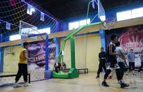 图为李来全(左一)在篮球馆内观看比赛(6月16日摄).