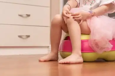 小女孩坐在坐便器上尿尿