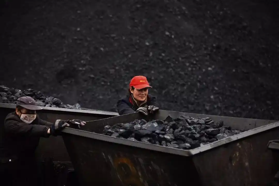 煤矿职工通过车辆在储煤场内装运煤炭.