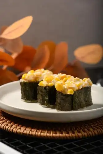 桌面上的盘子里的美味可口的玉米军舰寿司