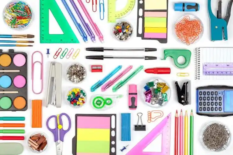 白色背景上摆放整齐的各种文具用品
