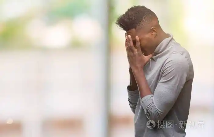 年轻的非裔美国人在孤独的背景上悲伤的表情用手捂住脸一边哭抑郁的