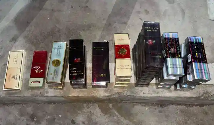 店门被打开并且有被撬的痕迹,货柜里的香烟,酒以及抽屉内现金被扫荡一