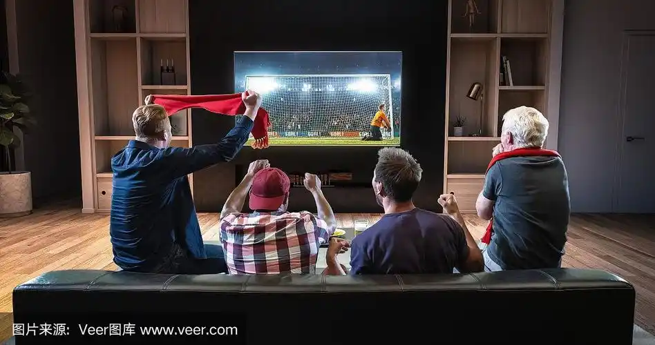 一群球迷正坐在客厅的沙发上观看电视上的足球时刻,庆祝进球.