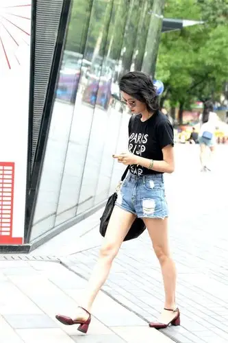 街拍:身材骨感的美女,搭配一条蓝色破洞中腰牛仔短裤,简约时尚