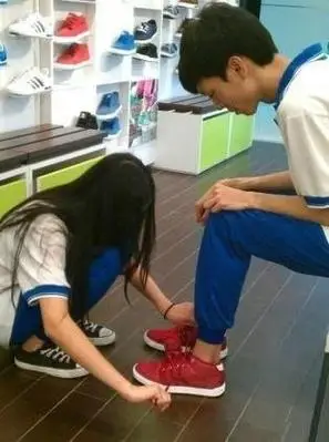 找一张女生给男生系鞋带的图片