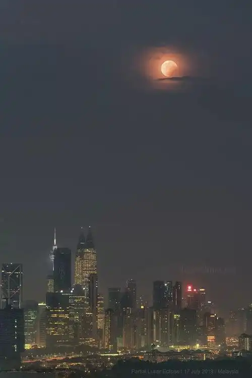 月偏食下的城市天际线夜空中国