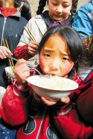 火终于生起来了.躲在墙根吃饭的孩子们.