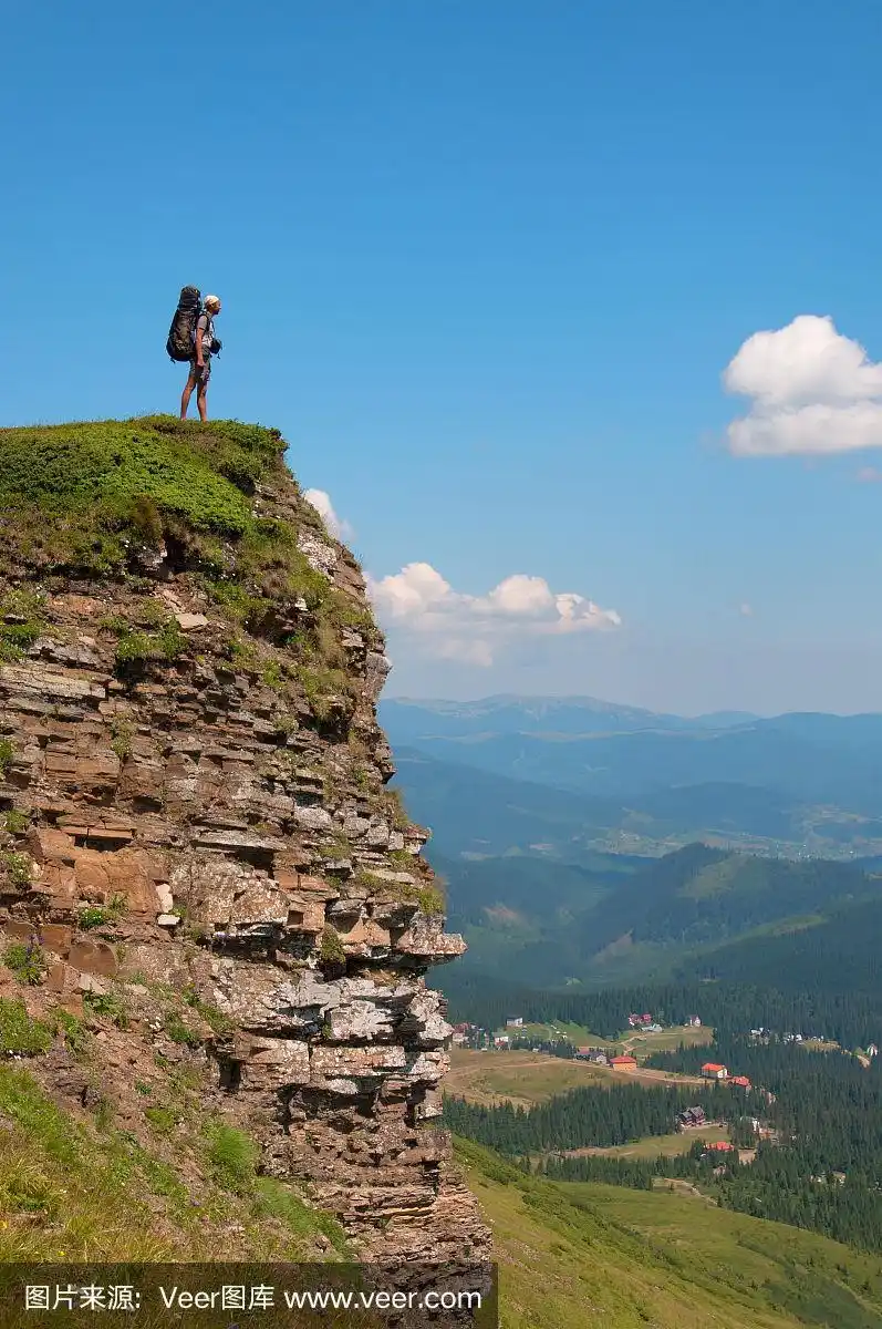 一个背着背包的人站在悬崖上