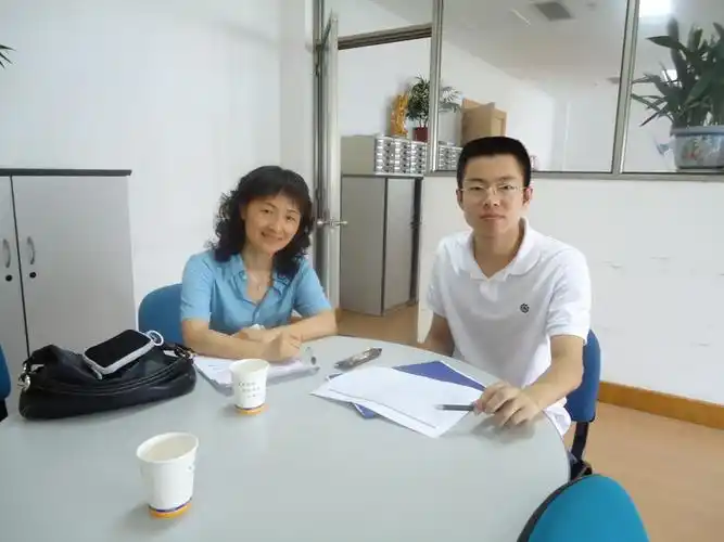 (很少在办公室照相,一位大学的老师来公司造访和她一起合影)