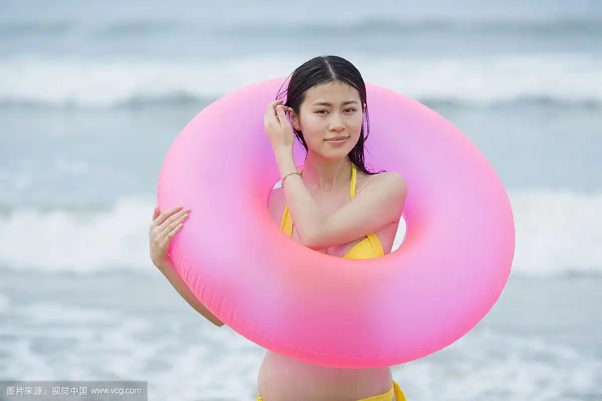海边拿游泳圈的女子