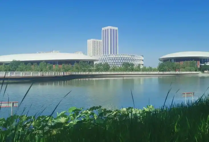 图为梨城库尔勒天鹅河畔的市民中心远眺.