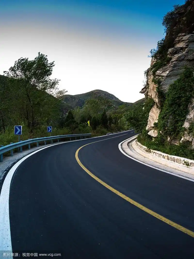 蜿蜒的盘山公路新铺的沥青路面与黄色分界线