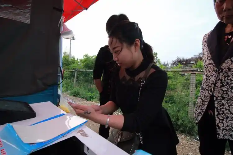 90后残疾妈妈1天2次摆摊为他人洗照片留美好回忆