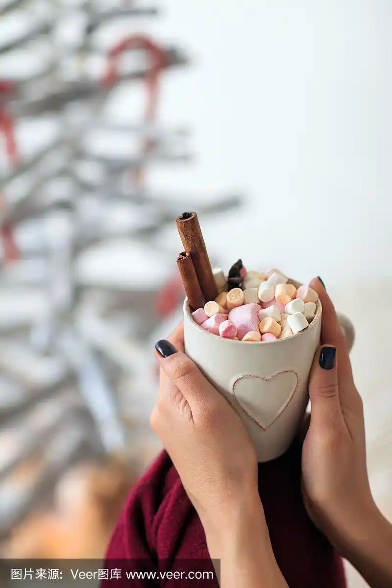 女人手里拿着一杯热巧克力和棉花糖