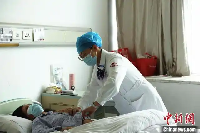 阮玉瑛在查看病人伤口. 朱柳融 摄